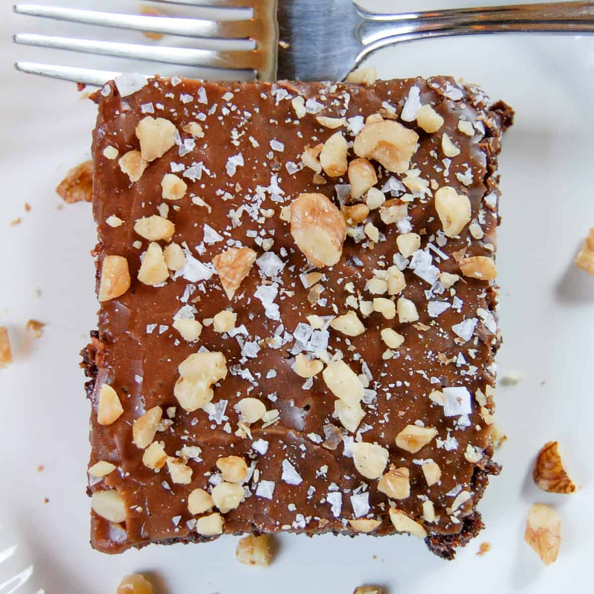 slice of texas chocolate sheet cake topped with chopped walnuts and flaked sea salt
