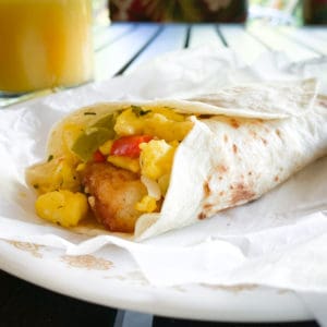 vegetarian breakfast burrito filled with scrambled eggs, tater tots, and sautéed peppers and onions