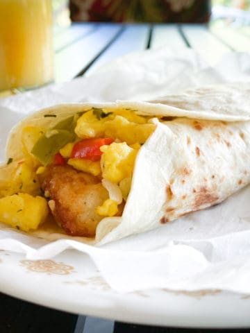 vegetarian breakfast burrito filled with scrambled eggs, tater tots, and sautéed peppers and onions