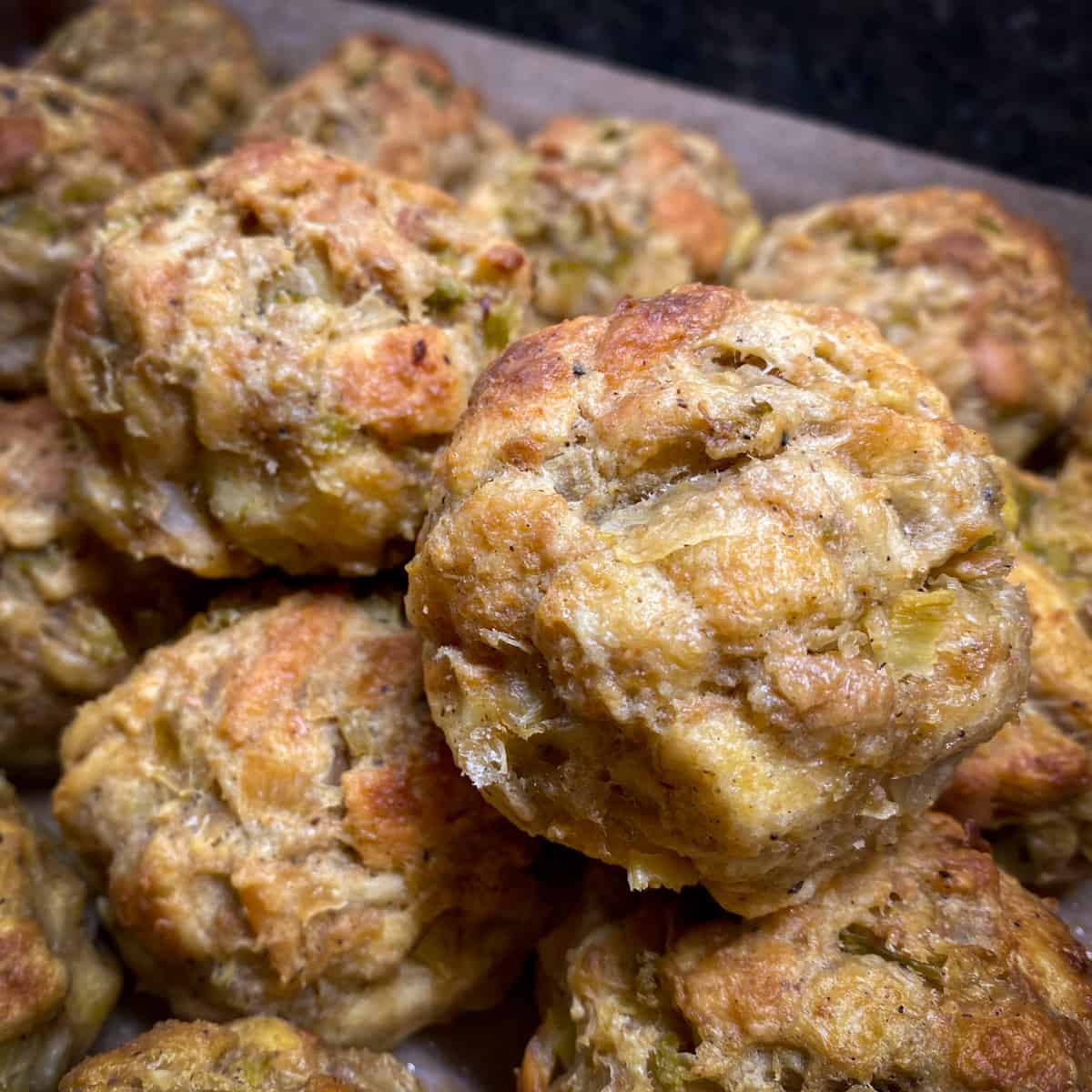 baked stuffing balls stacked on sheet pan