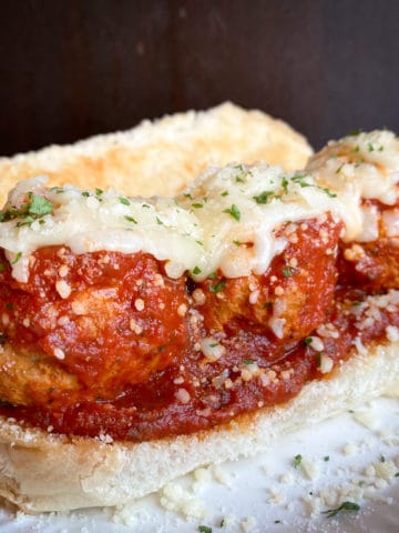 italian meatballs in red sauce with melted mozzarella on toasted bun