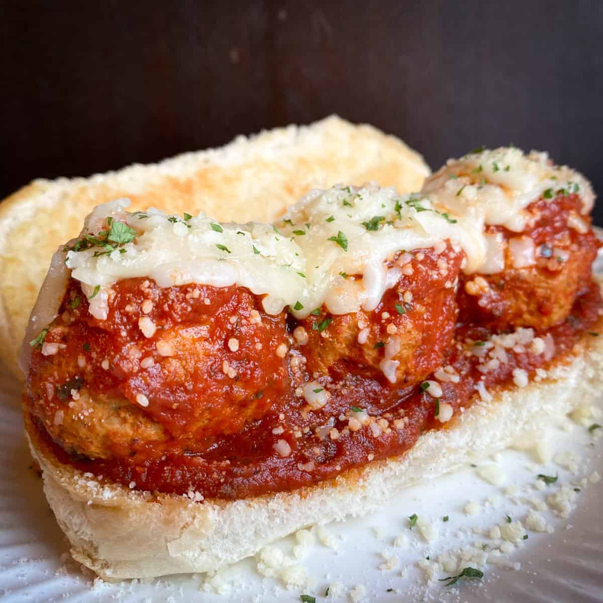 italian meatballs in red sauce with melted mozzarella on toasted bun