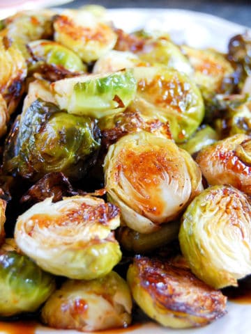 roasted brussels sprouts halves drizzled in chili glaze