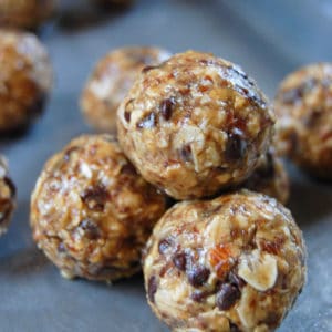 close up of energy balls made of peanut butter, oats, and mini chocolate chips on sheet pan