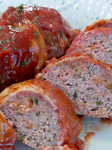 bacon wrapped mini meatloaf sliced on plate