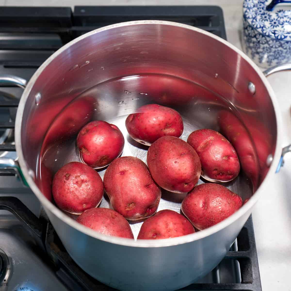 red skinned potatoes in pot of water on cooktop